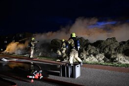 Grasstapel in brand. Grote rookwolk boven wijk De Waal