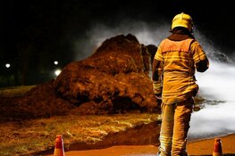 Grasstapel in brand. Grote rookwolk boven wijk De Waal